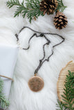 vintage gold locket surrounded by greenery on white fur background flat lay handmade in toronto
