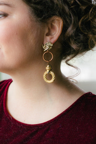 girl with curly hair wearing long gold hoop statement earrings handmade in toronto
