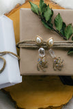 flat lay jewelry with presents on wood, pearl and gold statement earrings with vintage crystals handmade in toronto
