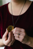 vintage gold locket with black chain on red velvet dress handmade in toronto